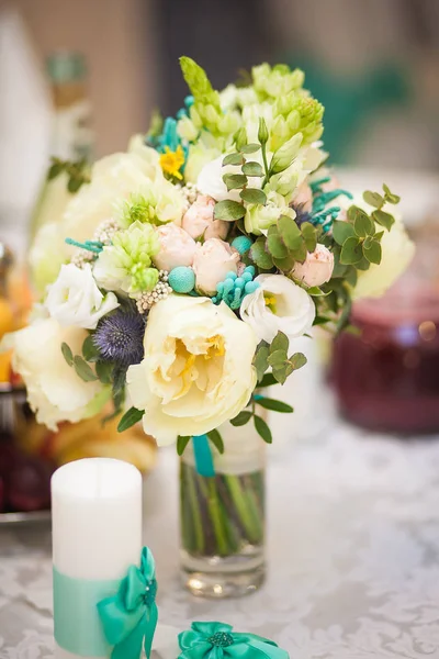 Wedding bouquet beige turquoise flowers in a transparent vase. Wedding decorations