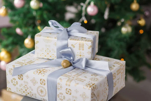 Beautiful silver and gold boxes with gifts under the Christmas tree. Close-up