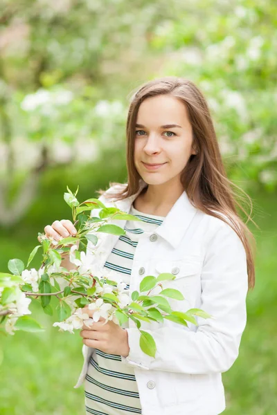 Piękna dziewczyna dmuchanie. portret dziewczyny w kwitnącej jabłoni. — Zdjęcie stockowe