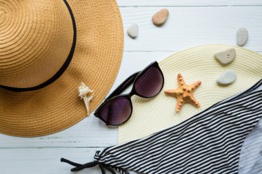 Beyaz arka planda güneş gözlüğü, şapka ve mayo. Sahilde tatil.