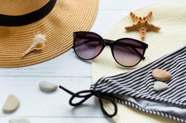 Beyaz arka planda güneş gözlüğü, şapka ve mayo. Sahilde tatil.