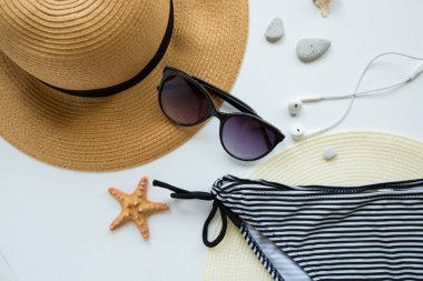 Beyaz arka planda güneş gözlüğü, şapka ve mayo. Sahilde tatil.