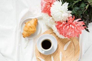 Kahve kahvaltısı, beyaz yatakta kruvasan.