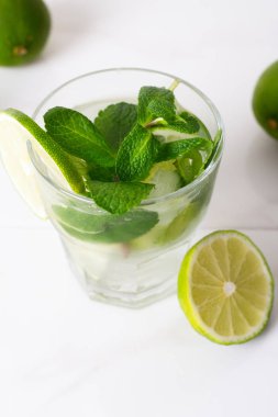 , mojito limonlu su içmek ve beyaz bir arka plan üzerine nane