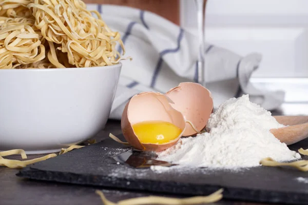 Kırık yumurta, un ve yumurta noodle ve mutfak masasının üzerinde şarap yakın çekim bir bardak