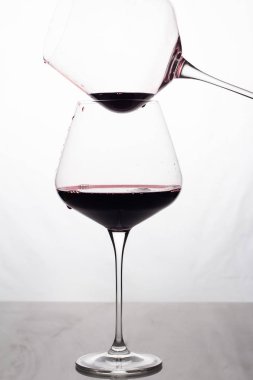 İki bardak beyaz zemin üzerine kırmızı şarap ile