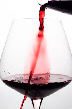 kırmızı şarap bardağa dökülüyor.
