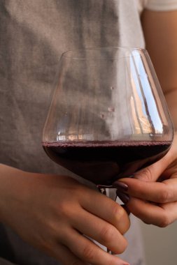 bir bardak kırmızı şarap tutan önlük kadında u kapatın