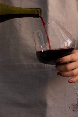 Erkek yağan kırmızı şarap bir şişe glas eller