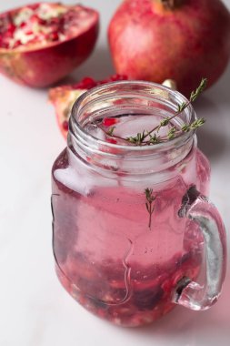 serinletici içecek bir bardak nar ile ve kekik bir beyaz adam buz ve nar dilimleri ile