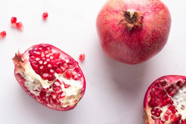 Kırmızı nar ve nar taneleri beyaz bir arka plan üzerinde