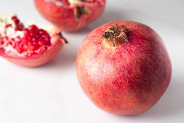 Kırmızı nar ve nar taneleri mermer bir zemin üzerine