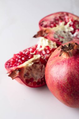 Kırmızı nar ve nar taneleri beyaz arka plan yakın çekim ve metin için yer
