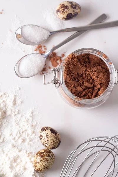 cocoa, eggs, flour and sugar on a white background top vie
