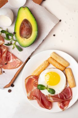 Kahve, meyve, avokado ve et içeren farklı kahvaltı yemekleri.