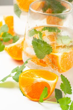 Portakallı ve naneli bir bardakta ferahlatıcı içecek.