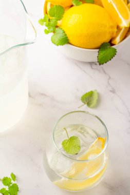 Beyaz arka planda buzlu, naneli ve limonlu içecek.