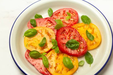 Bir tabak domates ve fesleğen salatası.