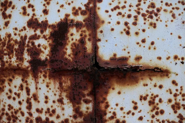 The metal surface rusted spots. Rysty corrosion. Corroded white metal background. Rusted white painted metal wall. Rusty metal background with streaks of rust. Rust stains.