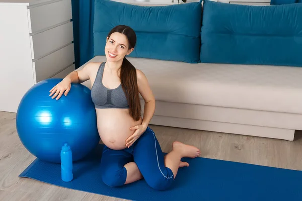 Femme enceinte avec ballon en forme à la maison — Photo