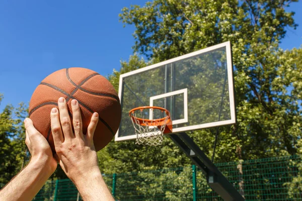 Manos lanzando pelota de baloncesto — Foto de Stock