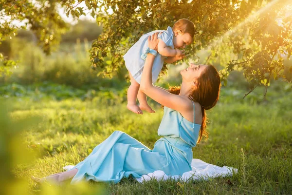 Matka s malou dcerou hraje na zelené trávě — Stock fotografie