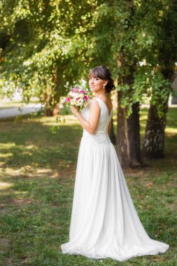 Beyaz gelinlik içinde gülümseyen güzel gelin