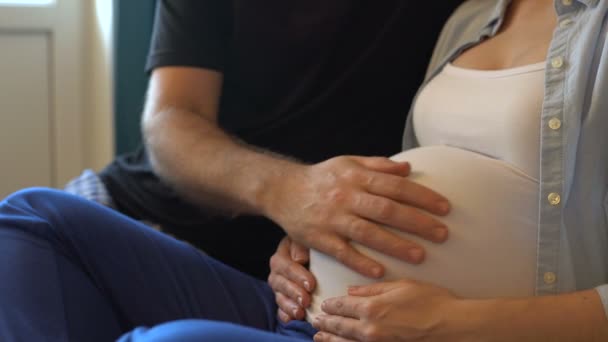 Чоловік погладжує вагітний живіт — стокове відео