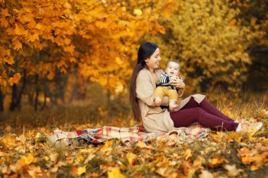Anne ve oğlu sonbahar parkında.