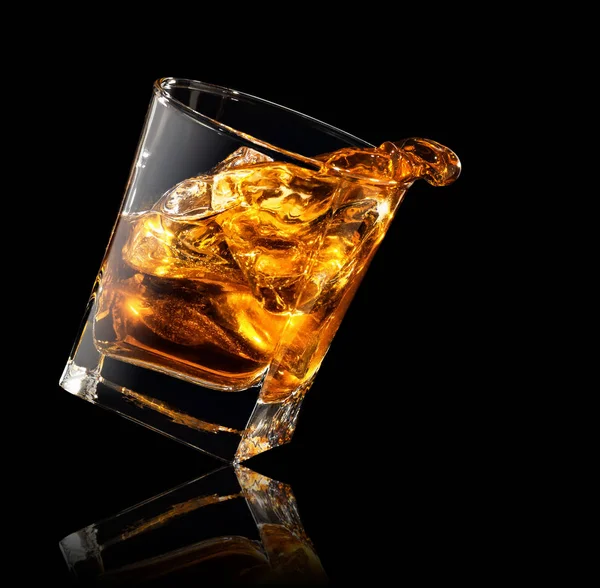 Splash van whisky in glas — Stockfoto