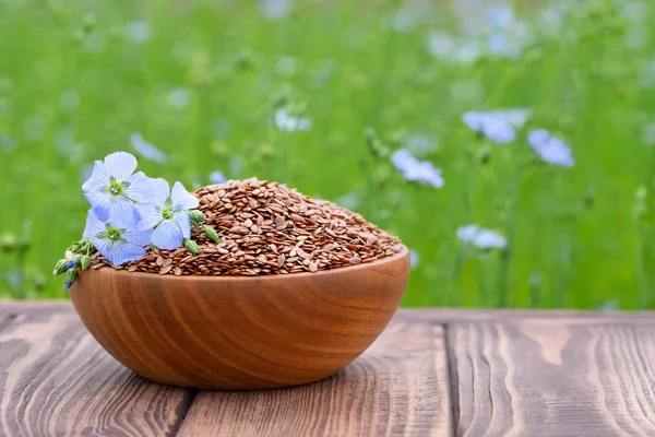 Flax seeds and flowers in bowl — Stock Photo, Image