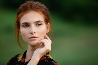 Güzel genç bir kadının açık hava portresi.