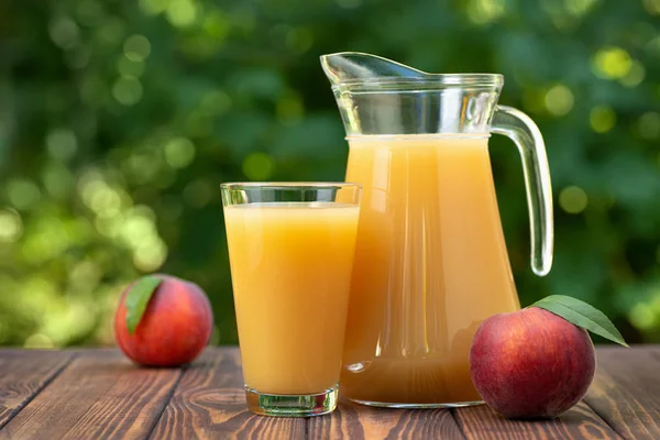 Peach juice in glass and jug — Stock Photo, Image