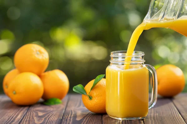 Zumo de naranja vertiendo en vidrio — Foto de Stock