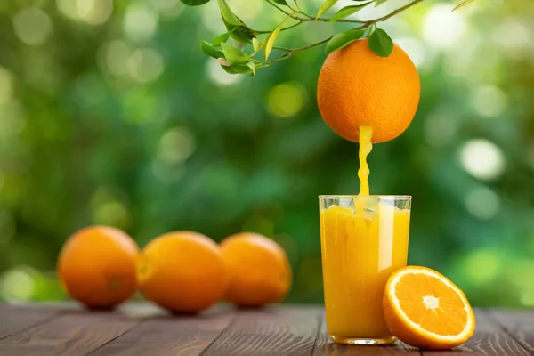 Apelsinjuice som hälls i glas — Stockfoto