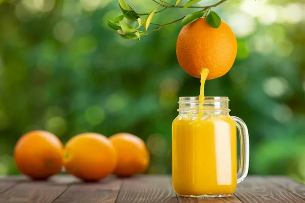 Succo d'arancia versando in vaso di muratore — Foto Stock