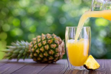 Ananas suyu bardağa dökülüyor.