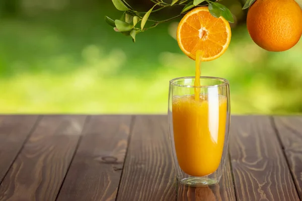 Apelsinjuice som hälls i glas — Stockfoto