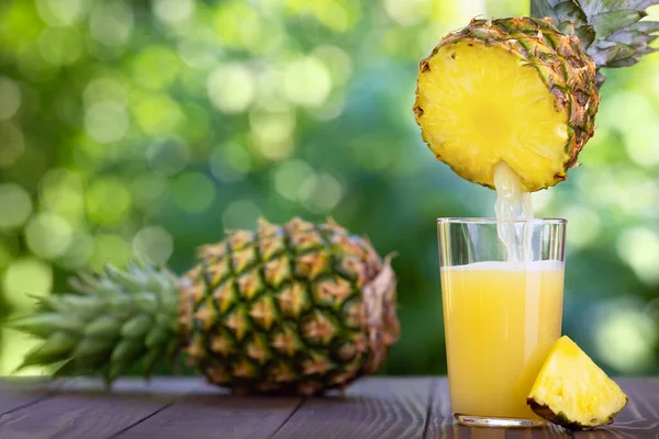 Pineapple juice pouring into glass — Stock Photo, Image