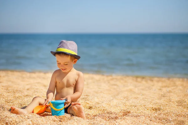 Küçük çocuk deniz sahilinde oynuyor.