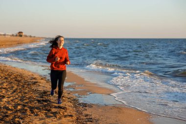 Plajda koşan fitness kadını