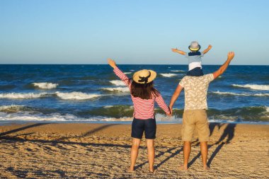 Anne ve baba oğluyla yürüyor.