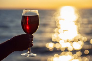 Elinde bir kadeh kırmızı şarap.