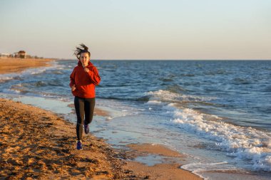 Kumsalda koşan kadın.