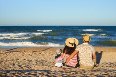 Anne ve baba oğluyla yürüyor.