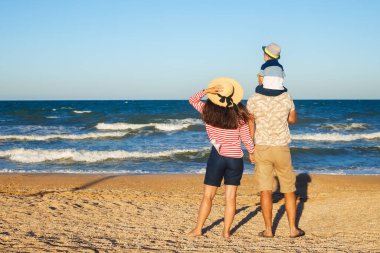 Anne ve baba oğluyla yürüyor.