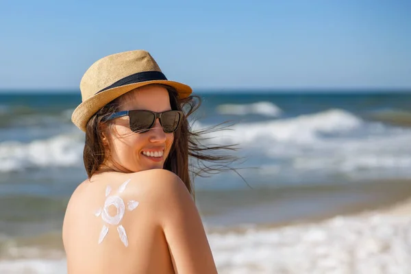 woman with sunscreen cream on the shoulder