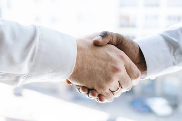Close-up handshaking of two colleagues African business man and Caucasian businessman .