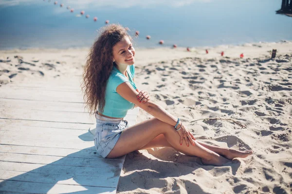Güzel Kıvırcık Kız Sahilde Oturuyor Tatil Ruh Yan Görünüm Portre — Stok fotoğraf