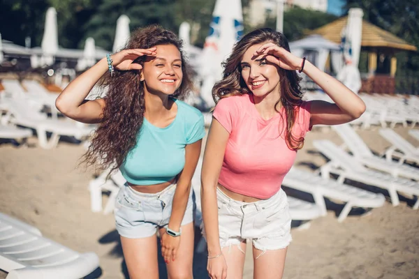 Happy summer hot time of happy young women in attractive clothes.Two trendy cool hipster girls, friends, pretty brunette having fun to camera